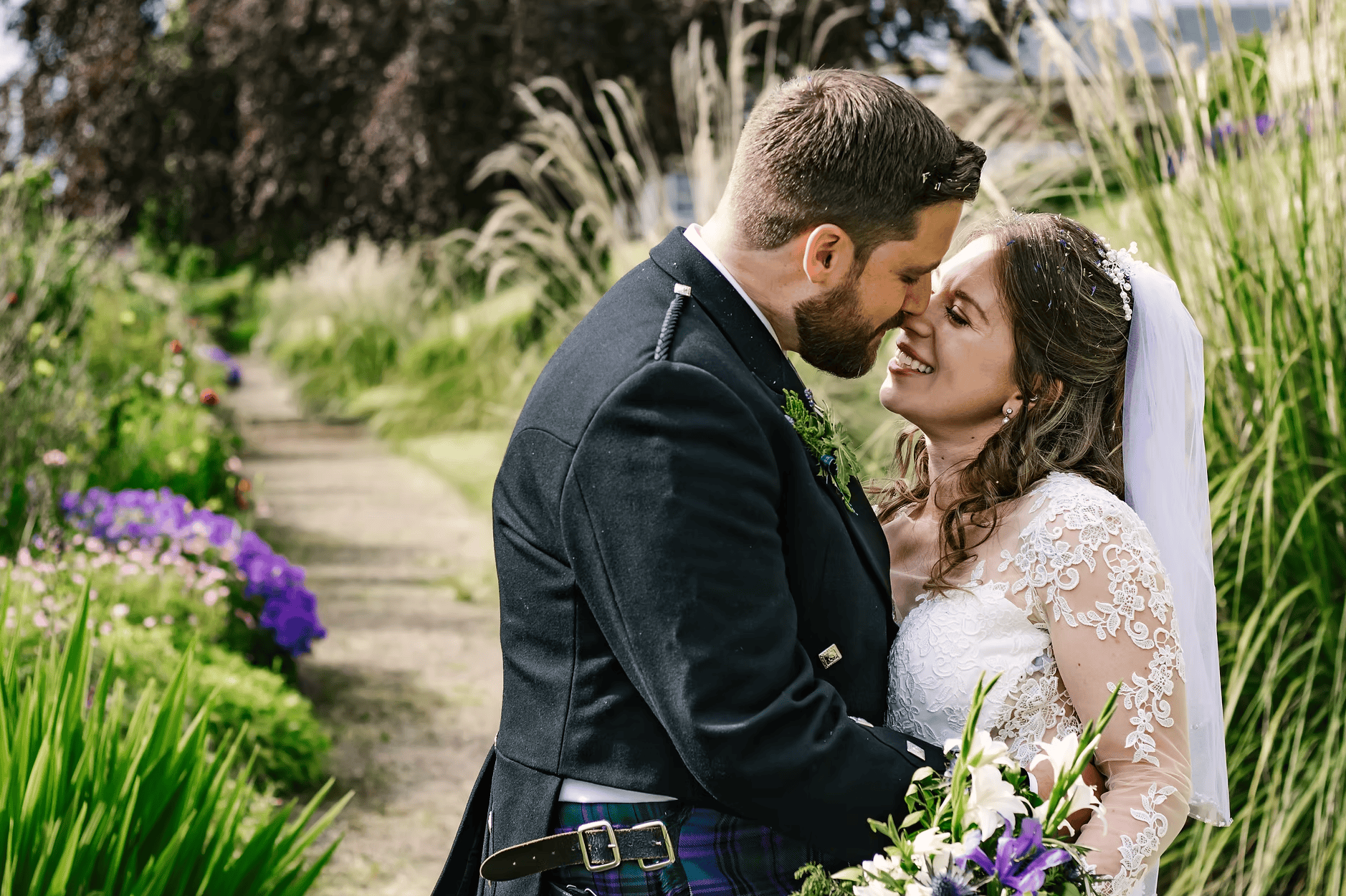 Bride and groom sharing a tender moment in a Scottish flower garden